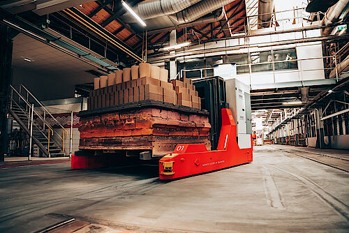 Mit maßgeschneiderten Transportrobotern der Serie CUSTOM MOVE werden passgenaue Transportlösung realisiert. Maßangefertigter Transportroboter in einer großen Halle der Feuerfestindustrie